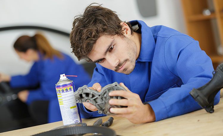 Feinwerkmechaniker arbeitet an Autoteilen.