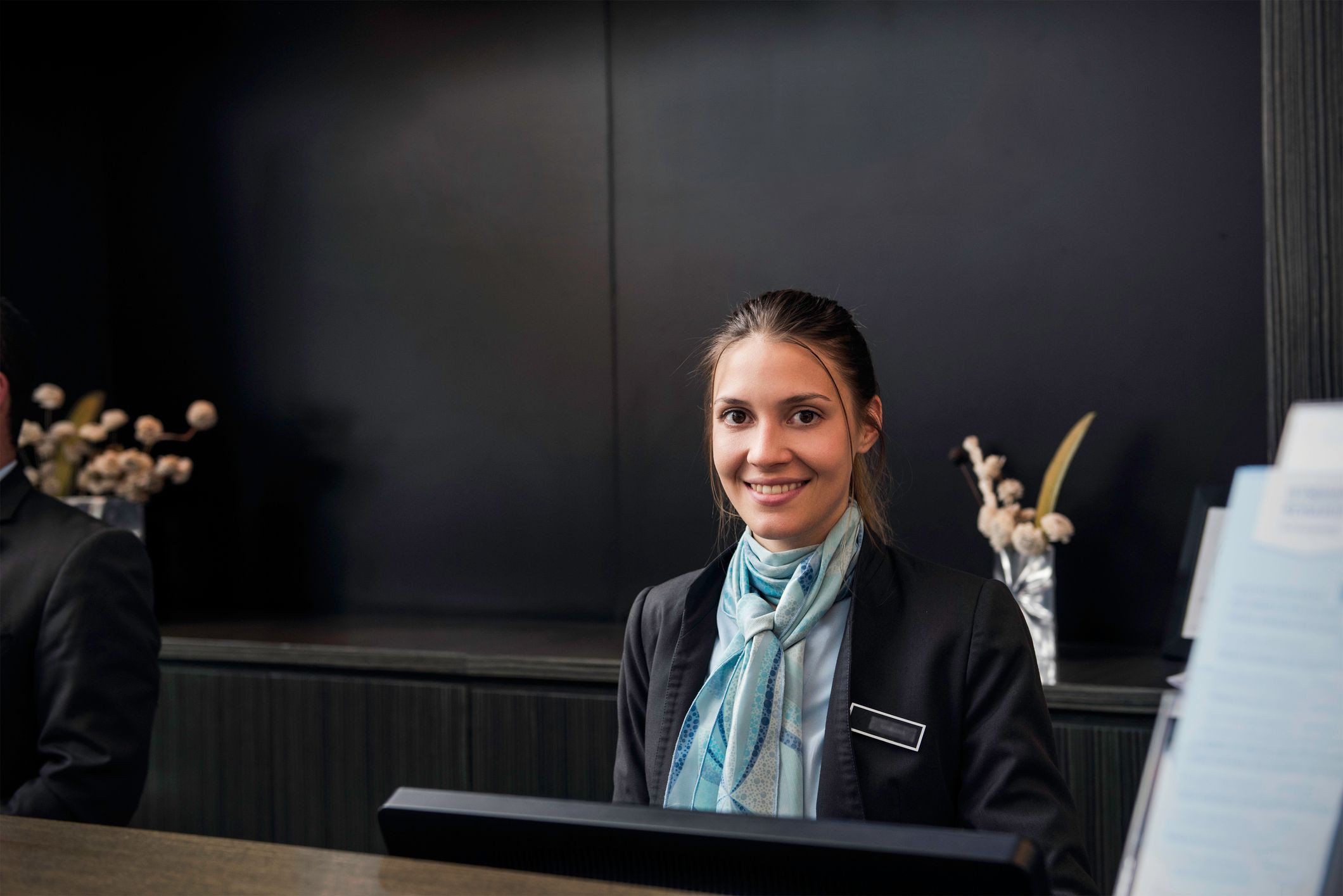 Hotelfachfrau-Auszubildende am Empfang eines Hotels