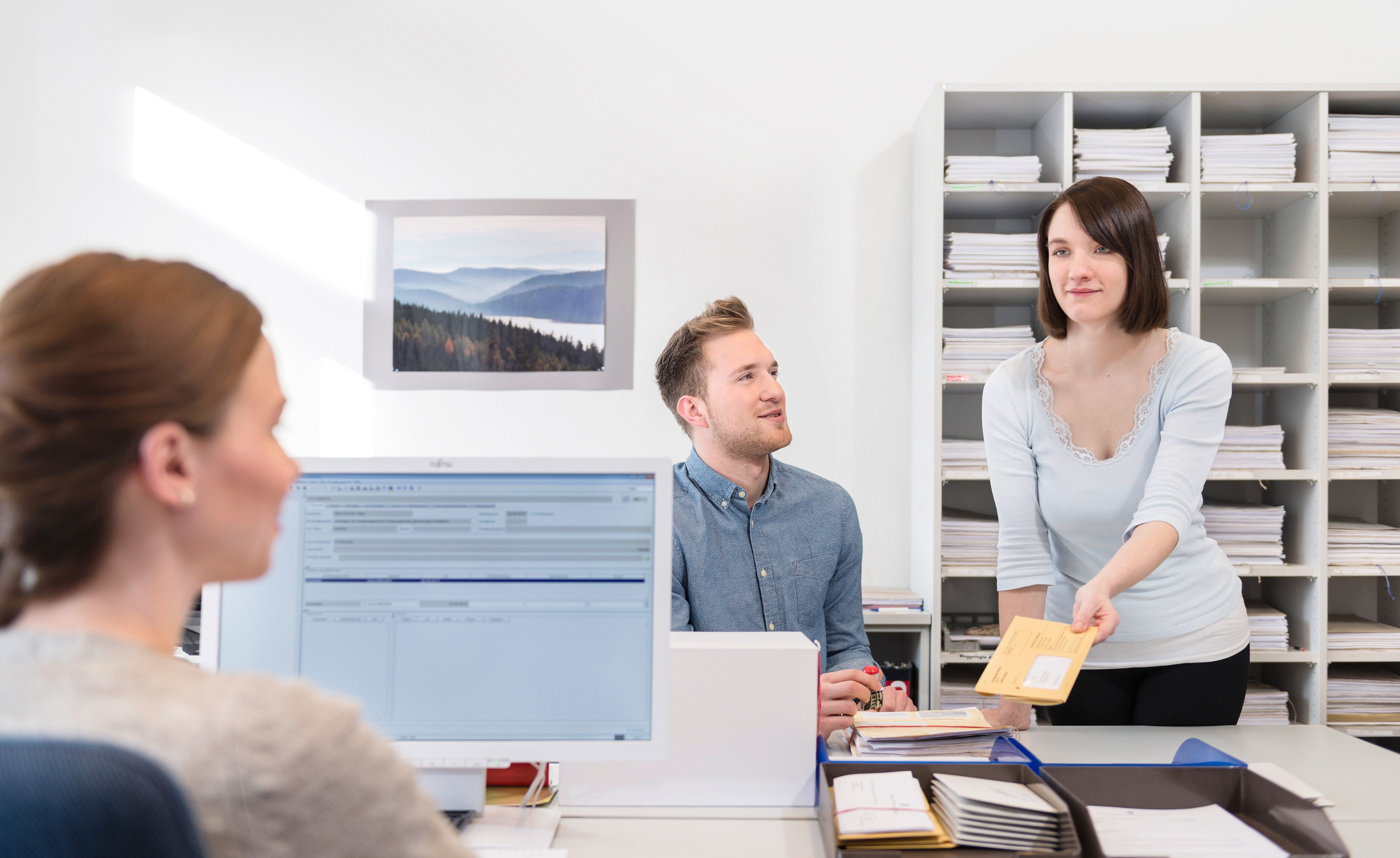 Drei Justizfachangestellte bei der Arbeit im Büro.