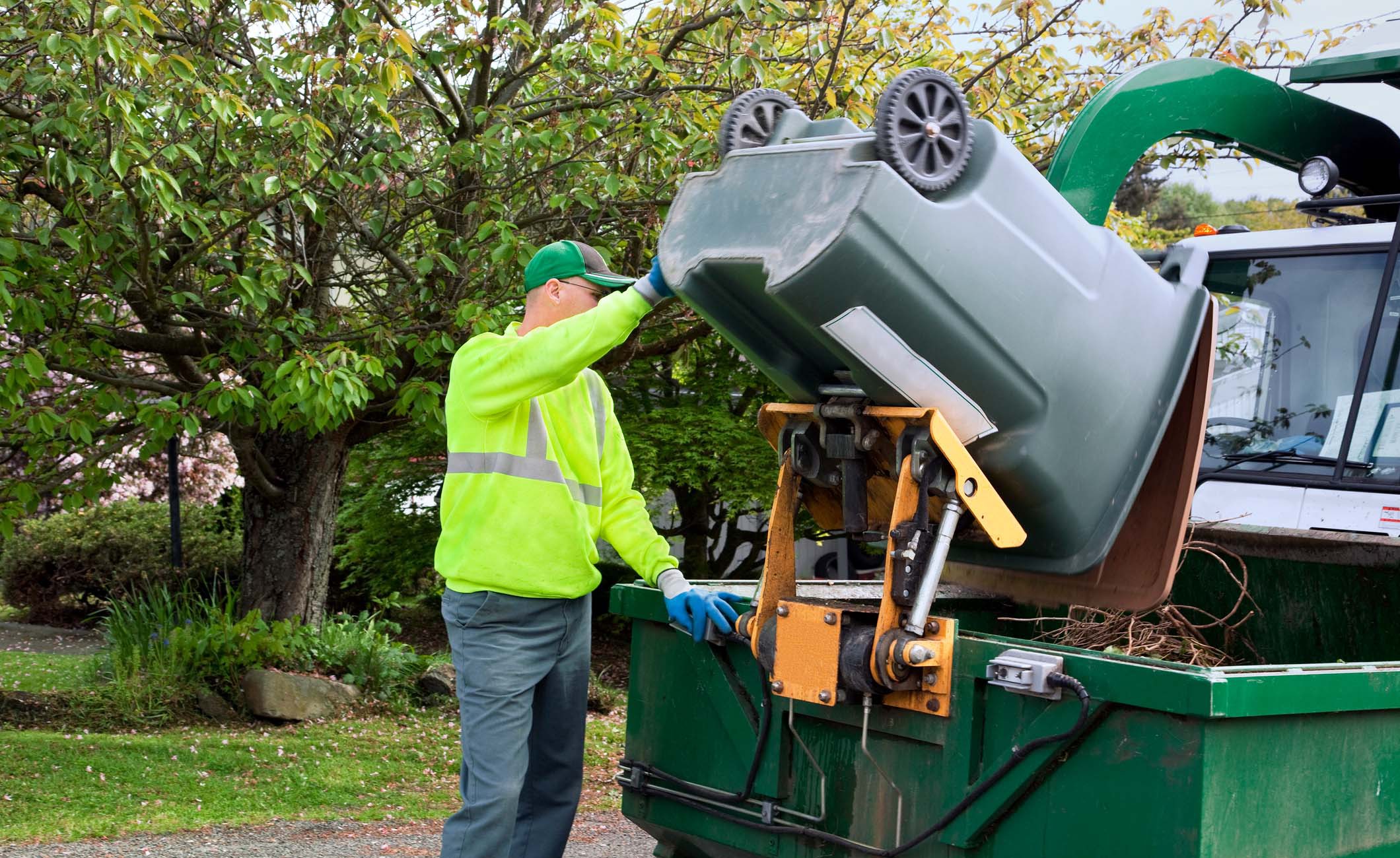 Müllmann entlädt Mülltonne in einem Container