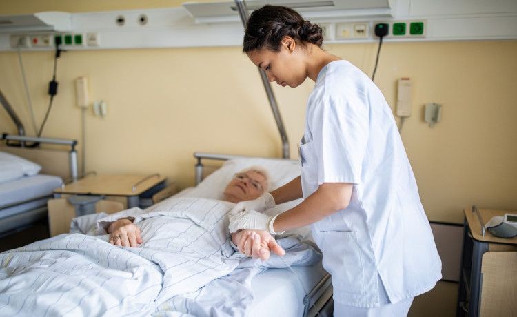 Altenpflegerin kümmert sich um eine Patientin.