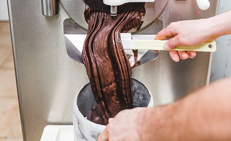 Schokoladenteig fließt aus einer Teigmaschine.