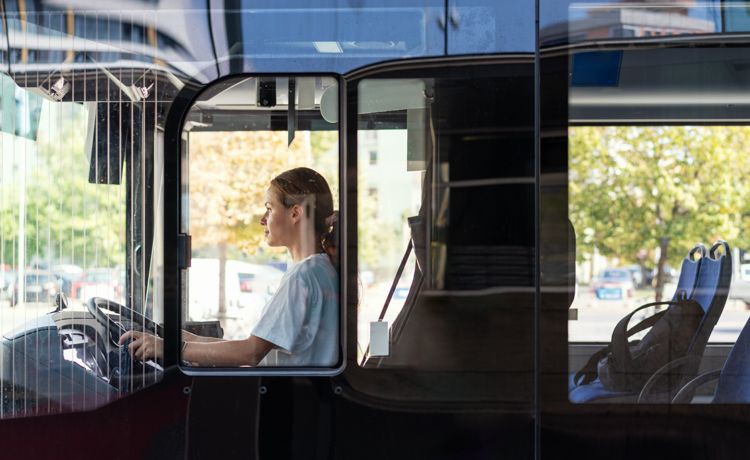 Eine Auszubildende zur Berufskraftfahrerin steuert einen Bus.