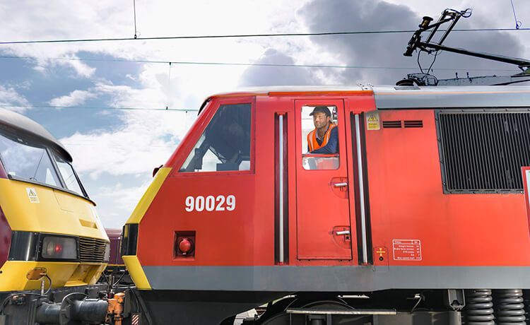 Lokführer sitzt in einem Zug und blickt aus dem Zugfenster.