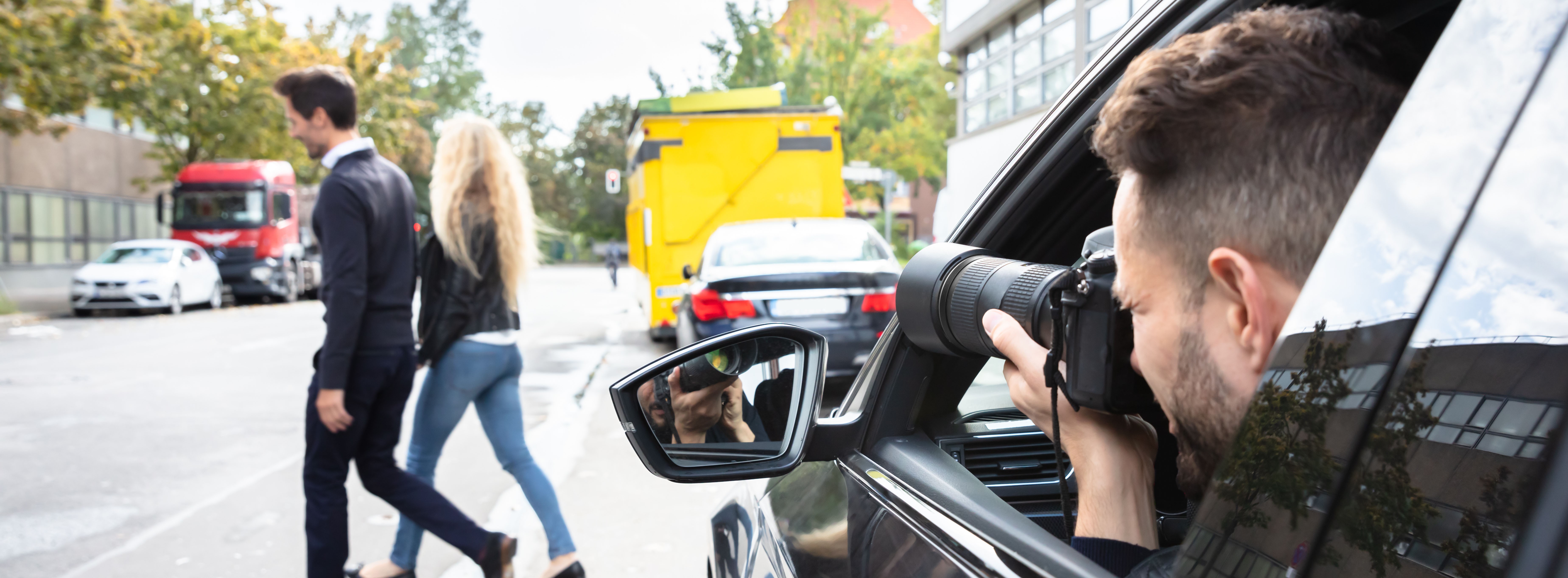 Privatdetektiv fotografiert Mann und Frau auf der Straße.