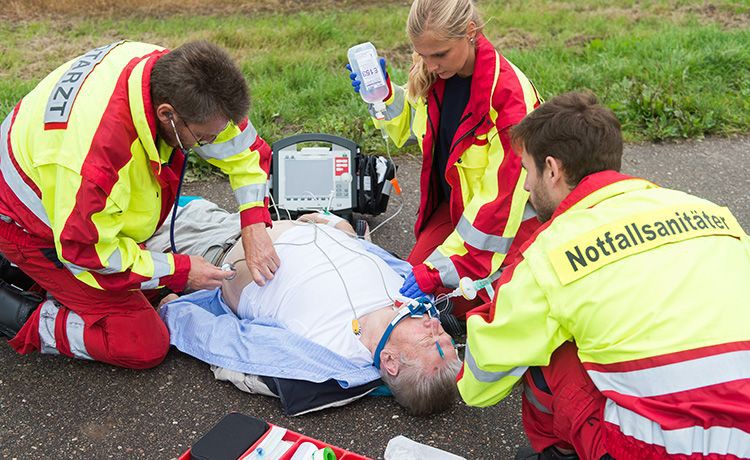 Notfallsanitäter kümmert sich zusammen mit einem Notarzt um die Versorgung eines Patienten am Unfallort.