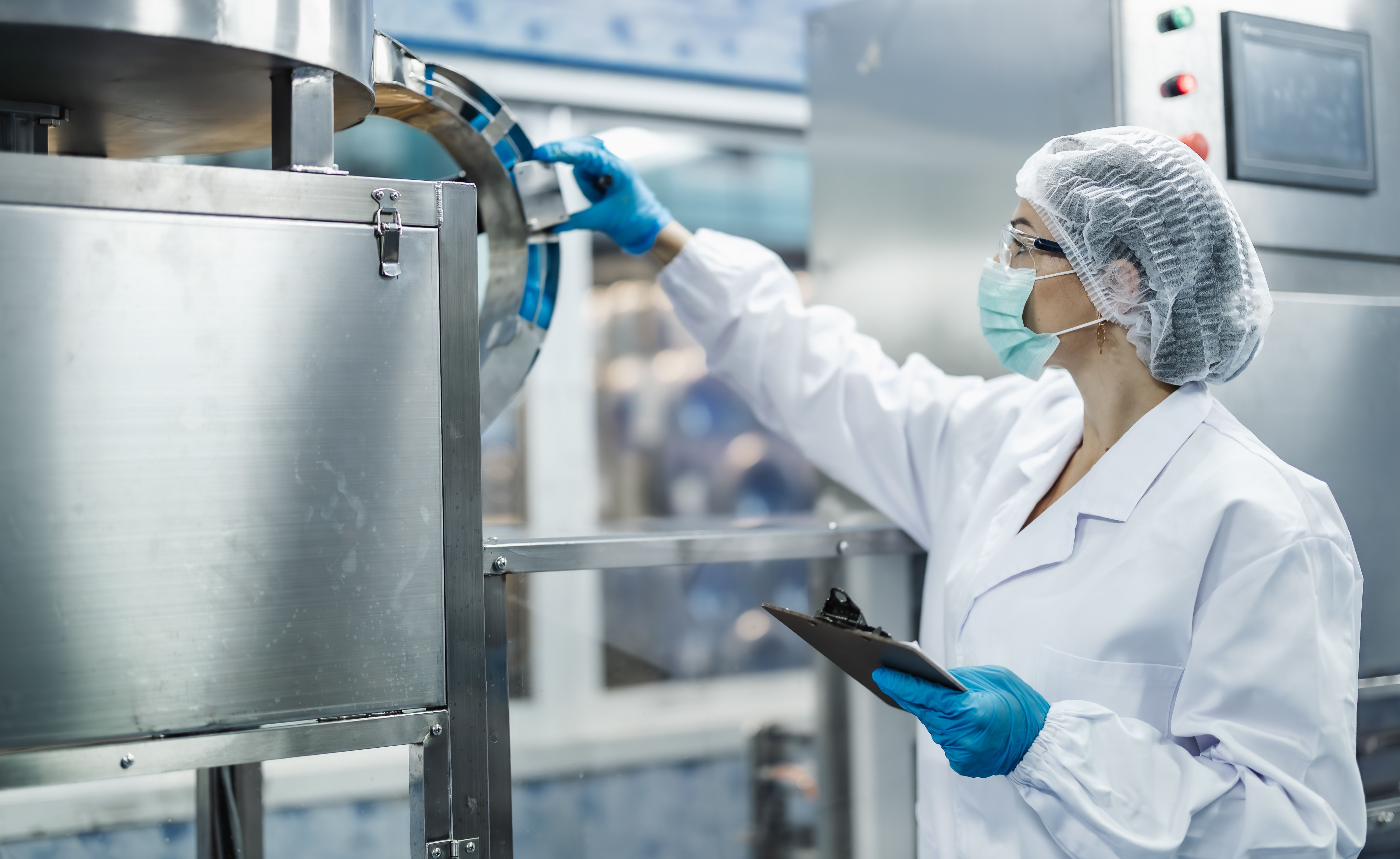 Industrieinspektor*innen bei der Arbeit – Qualitätskontrollpersonal überprüft den Maschinenbetrieb auf Sicherheit und Hygiene in einer Getränkeproduktion.