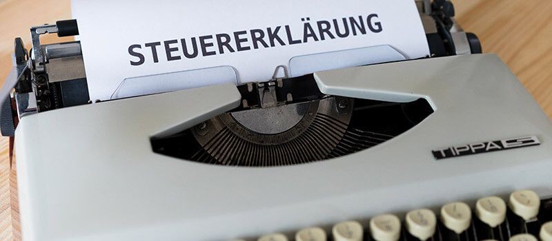 Bild von einer Schreibmaschine in der ein Blatt mit der Aufschrift "Steuererklärung" steckt.