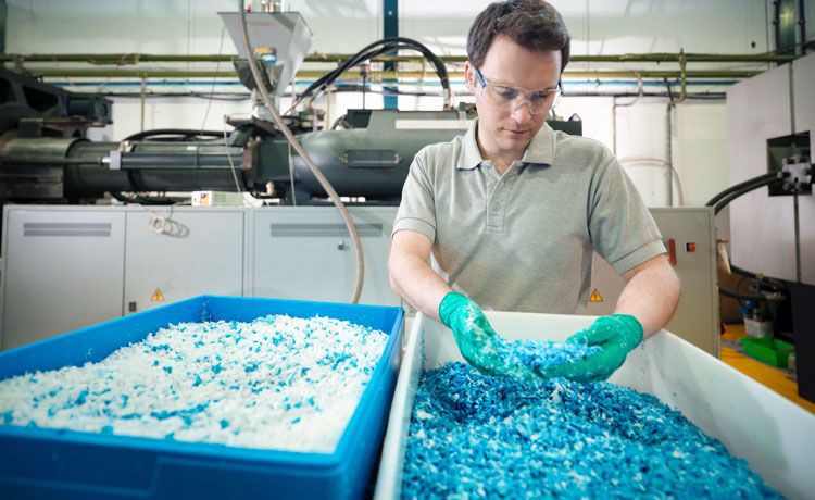 Ein Verfahrensmechaniker für Kunststoff- und Kautschuktechnik kontrolliert Kunststoff-Granulat.